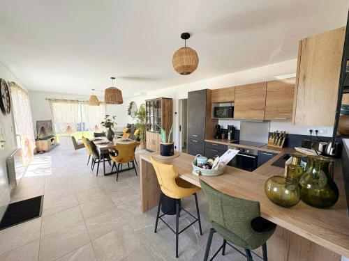 une cuisine et un salon avec une table et des chaises dans l'établissement Les Rochers - Raffinement boisé & Plage à 5 min en voiture - Sérénité, à Brétigny