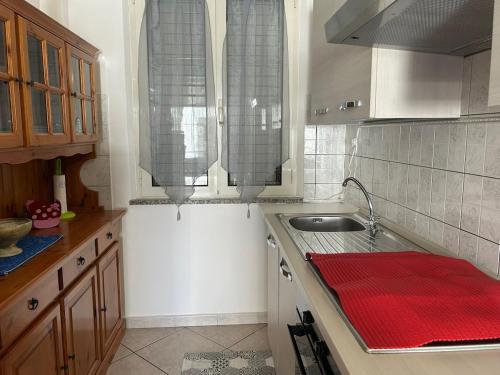 a kitchen with a sink and a red towel on the counter at Domo Mea in Cardedu