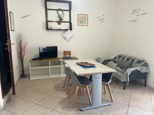a dining room with a table and chairs and a desk at Domo Mea in Cardedu