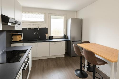 une cuisine avec une table en bois et un réfrigérateur dans l'établissement Spacious And Quiet Apartment, à Meythet