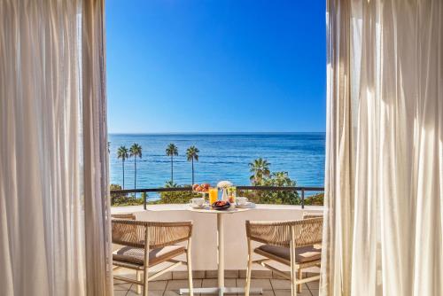 a dining room with a table and a view of the ocean at Hôtel Barrière Le Majestic Cannes in Cannes