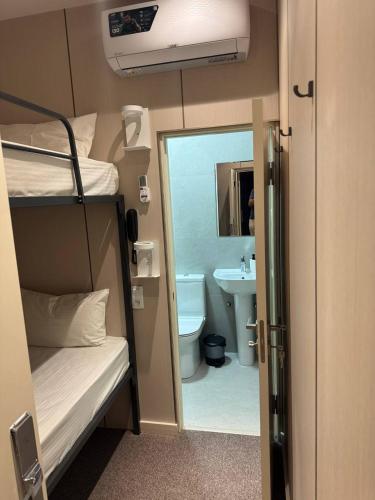 a small room with a bunk bed and a bathroom at City Centre B&B in Tashkent