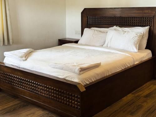a large bed with white sheets and pillows on it at PUSHPAM RANCHES And RESORT in Mattigiri