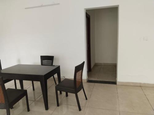 a dining room with a black table and chairs at PUSHPAM RANCHES And RESORT in Mattigiri