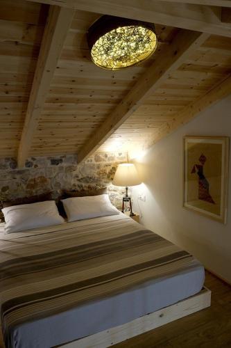 a bedroom with a bed and a ceiling with a chandelier at Casa dell'Arte Nafplio in Nafplio