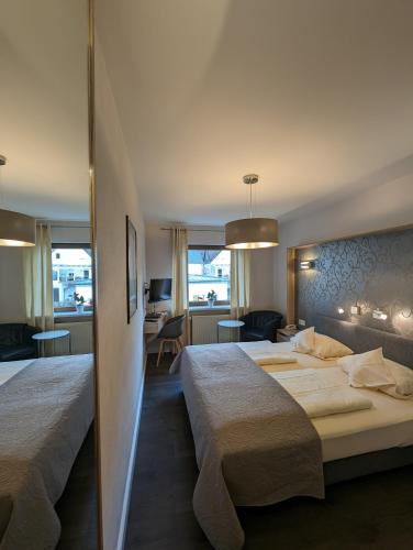 a hotel room with two beds and a living room at Weinhotel St. Stephanus in Zeltingen-Rachtig