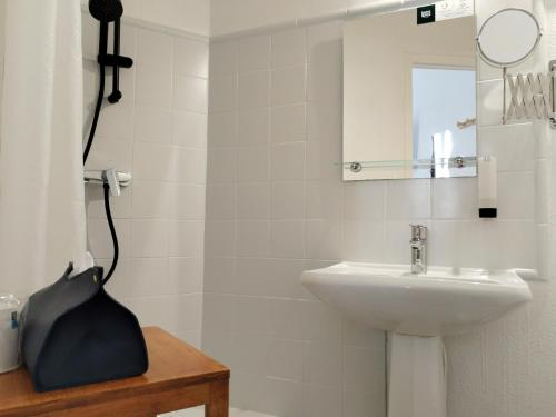 a white bathroom with a sink and a mirror at Logis Hôtel La Bastide d'Entraigues in Entraigues-sur-la-Sorgue