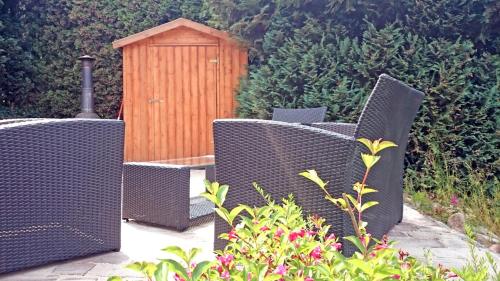 a group of wicker chairs and a wooden shed at Ferienwohnung Jan in Prohn