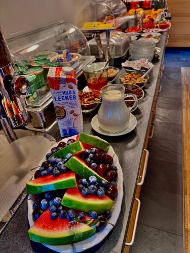 a buffet line with fruits and other food on it at Hotel Garni Otto Huber in Oberammergau