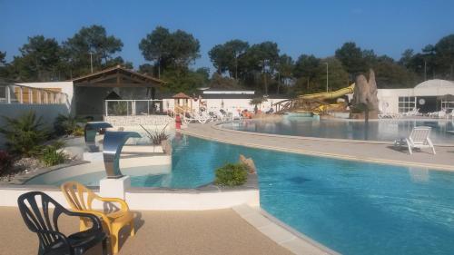 une grande piscine avec des chaises et un toboggan dans l'établissement Bontempo Village La Yole, à Saint-Jean-de-Monts