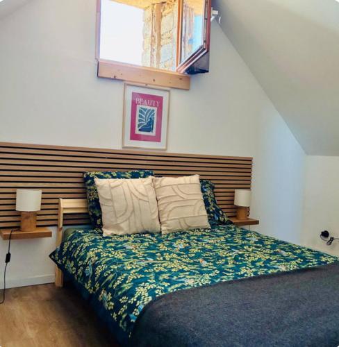 une chambre avec un lit avec une tête de lit en bois dans l'établissement La longère des plages, à Plougonvelin