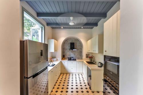 a kitchen with white cabinets and a blue ceiling at Villa Lluvia 5bhk-Huge Pvt Pool-Caretaker-Bathtub-Big Garden-Genset Backup- Siolim in Oxel