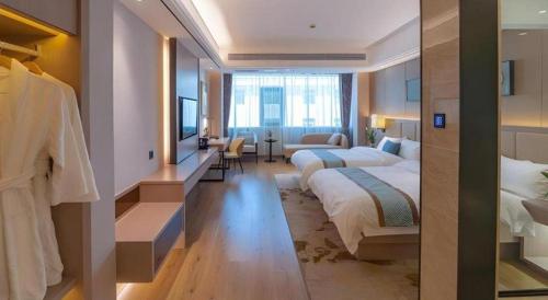 a hotel room with a bed and a living room at GreenTree Eastern Dali Railway Station Hotel in Dali