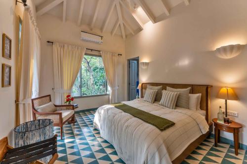 a bedroom with a large bed and a chair at Villa Lluvia 5bhk-Huge Pvt Pool-Caretaker-Bathtub-Big Garden-Genset Backup- Siolim in Oxel