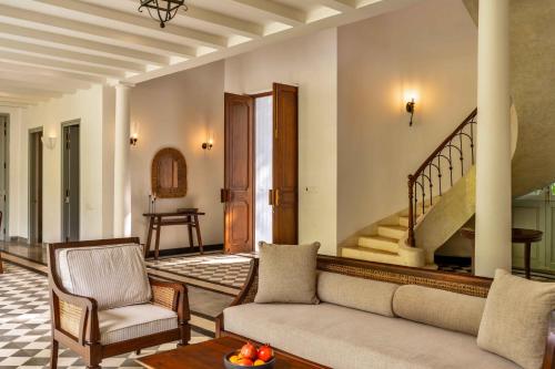 a living room with a couch and a staircase at Villa Lluvia 5bhk-Huge Pvt Pool-Caretaker-Bathtub-Big Garden-Genset Backup- Siolim in Oxel