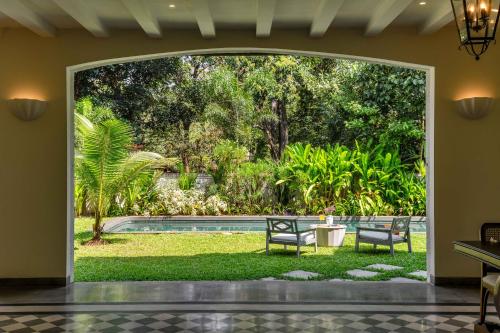 a view of a yard with two chairs and a table at Villa Lluvia 5bhk-Huge Pvt Pool-Caretaker-Bathtub-Big Garden-Genset Backup- Siolim in Oxel