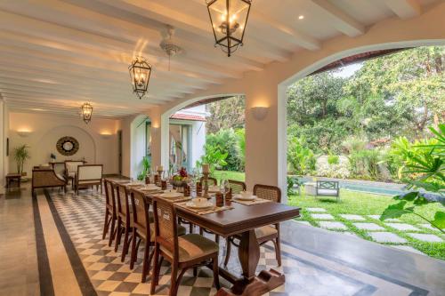 a dining room with a long table and chairs at Villa Lluvia 5bhk-Huge Pvt Pool-Caretaker-Bathtub-Big Garden-Genset Backup- Siolim in Oxel