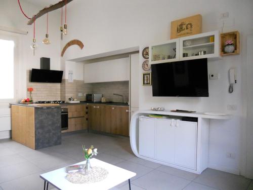a large white kitchen with a tv on the wall at La Colonica - 3 people - 5 min from Florence in Bagno a Ripoli