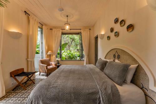a bedroom with a large bed and a window at Villa Lluvia 5bhk-Huge Pvt Pool-Caretaker-Bathtub-Big Garden-Genset Backup- Siolim in Oxel