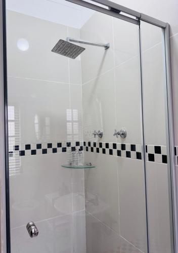 a shower with a glass door in a bathroom at 7 On Annandale B&B in East London