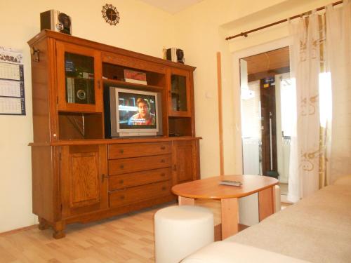 uma sala de estar com uma televisão num armário de madeira em Apartman Andrija em Opatija