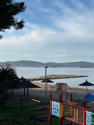 a playground on a beach next to the water at StayAdriatic Mobile Homes Olive in Sveti Filip i Jakov