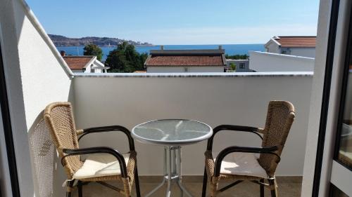 a table and two chairs on a balcony with a view at Apartments Kojic in Bar