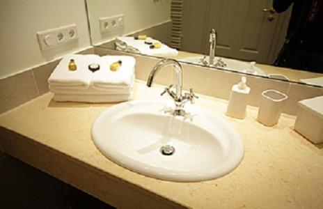 ein weißes Waschbecken im Bad mit Spiegel in der Unterkunft Jadgschloss zu Hohen Niendorf in Hohen Niendorf
