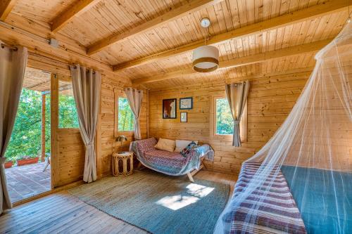 Cabaña de madera con hamaca en una habitación en La casetta nel bosco, en Asís