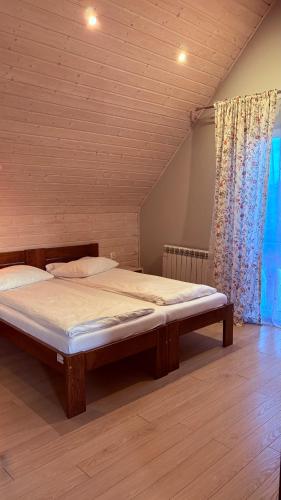 a bedroom with a large bed in a room at Świerkowa Chata in Bałtów