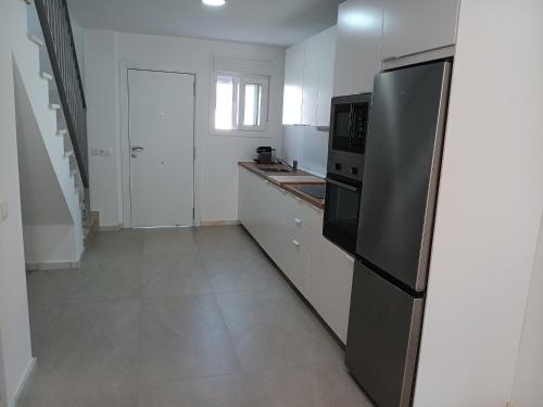 a white kitchen with a refrigerator and a sink at Chalet Zahara Beach in Zahara de los Atunes
