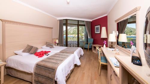 a hotel room with two beds and a desk at Hotel Aqua in Marmaris