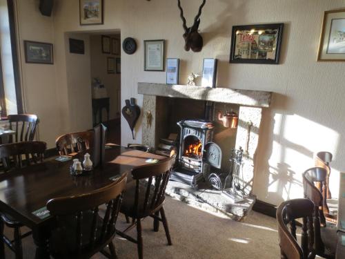 a dining room with a table and a fireplace at Pack Horse Inn in Mellor