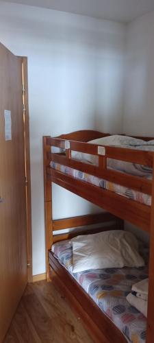 two bunk beds in a room with a closet at Chamrousse - Résidence La Grive in Chamrousse