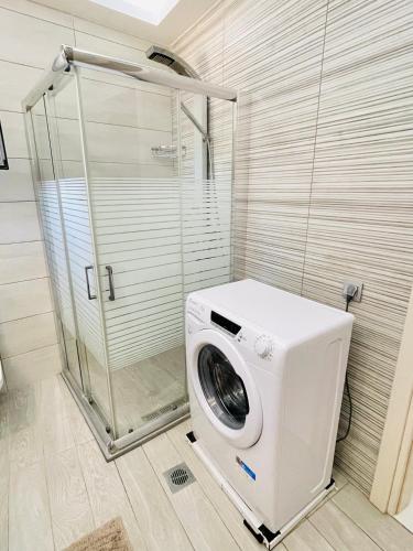 a washing machine in a bathroom with a shower at Marion Holiday House in Alykes