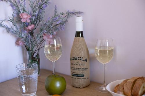 a bottle of wine and two glasses on a table at Olea Apartments in Razáta