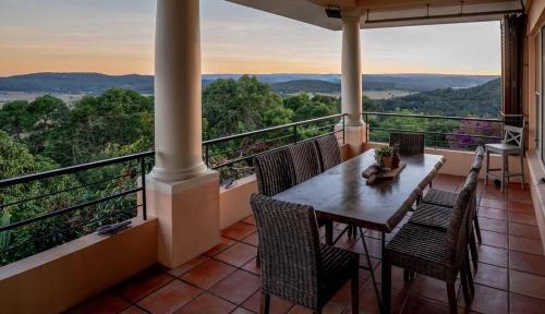 a porch with a table and chairs on a balcony at River Rock Retreat in Maroochy River
