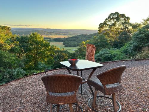 a table and chairs with a view of a valley at River Rock Retreat in Maroochy River