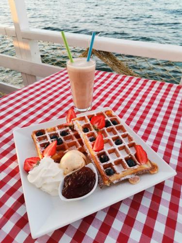 a plate of waffles and a drink on a table at Taverna & Rooms in Sutivan