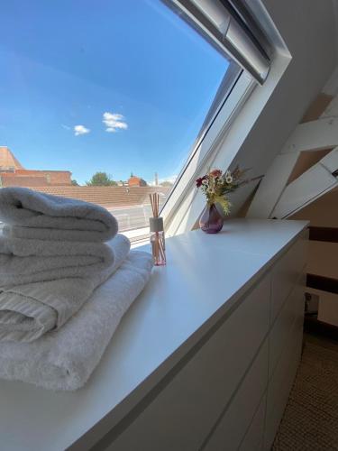 a pile of towels sitting on a counter next to a window at Cinestrings in Mons