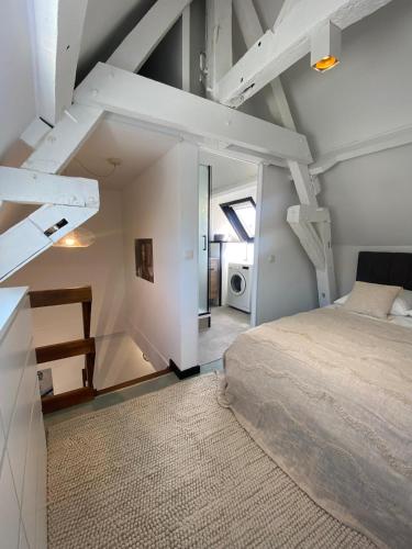 an attic bedroom with a bed and a staircase at Cinestrings in Mons