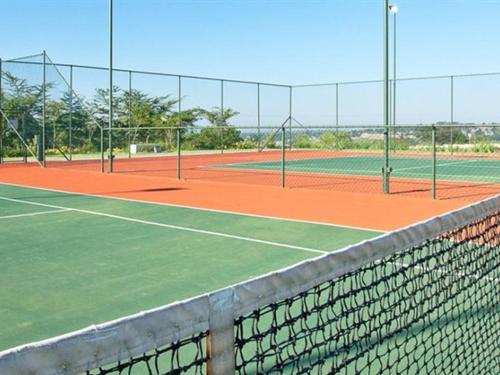 a tennis court with two tennis courts at Malaika Luxurious Crib, Jackal Creek Golf Estate, Northriding in Roodepoort