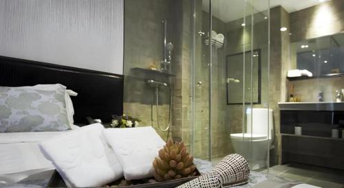 a bedroom with a shower and a bed with pillows at M1 North Point Hotel in Hong Kong