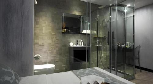 a bathroom with a shower and a toilet and a sink at M1 North Point Hotel in Hong Kong