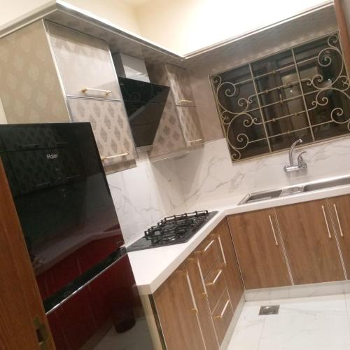 a small kitchen with a stove and a sink at Luxurious 2BR House in Dargai