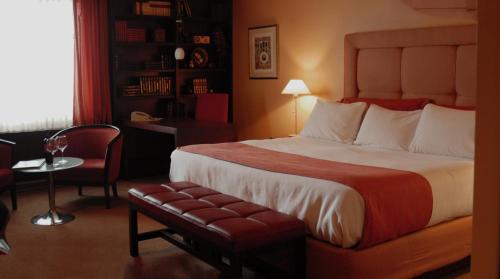 a hotel room with a large bed and a chair at Hôtel Mingan in Sept-Îles