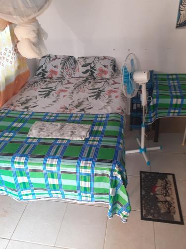 a bedroom with a bed with a green and blue comforter at SoSun House in Serekunda