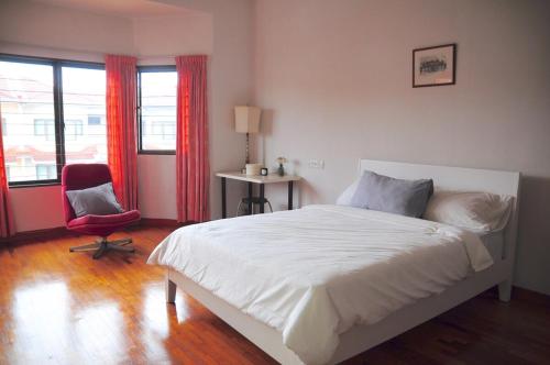 a bedroom with a bed and a chair and windows at GRAYHAUS 32 Spacious 3 Storey 5BR - Bandar Utama, near 1 Utama - Stay Only NO EVENTS in Petaling Jaya