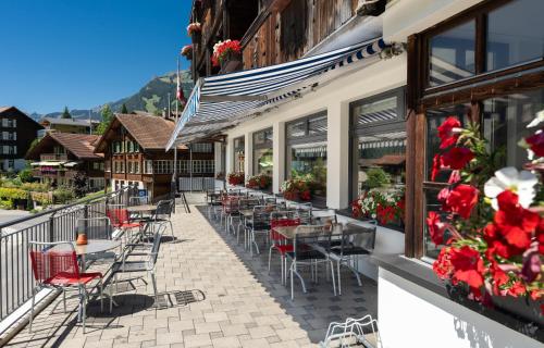 a row of tables and chairs outside of a building at Jungfrau Lodge, Swiss Mountain Hotel in Grindelwald