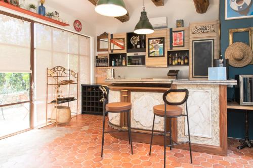 a bar with stools in a room with blue walls at Domaine Les Mésanges in Saint-Tropez